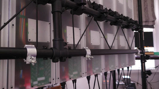 The back of a lighting rig showing LED panel backs, bracket connections, and cables 