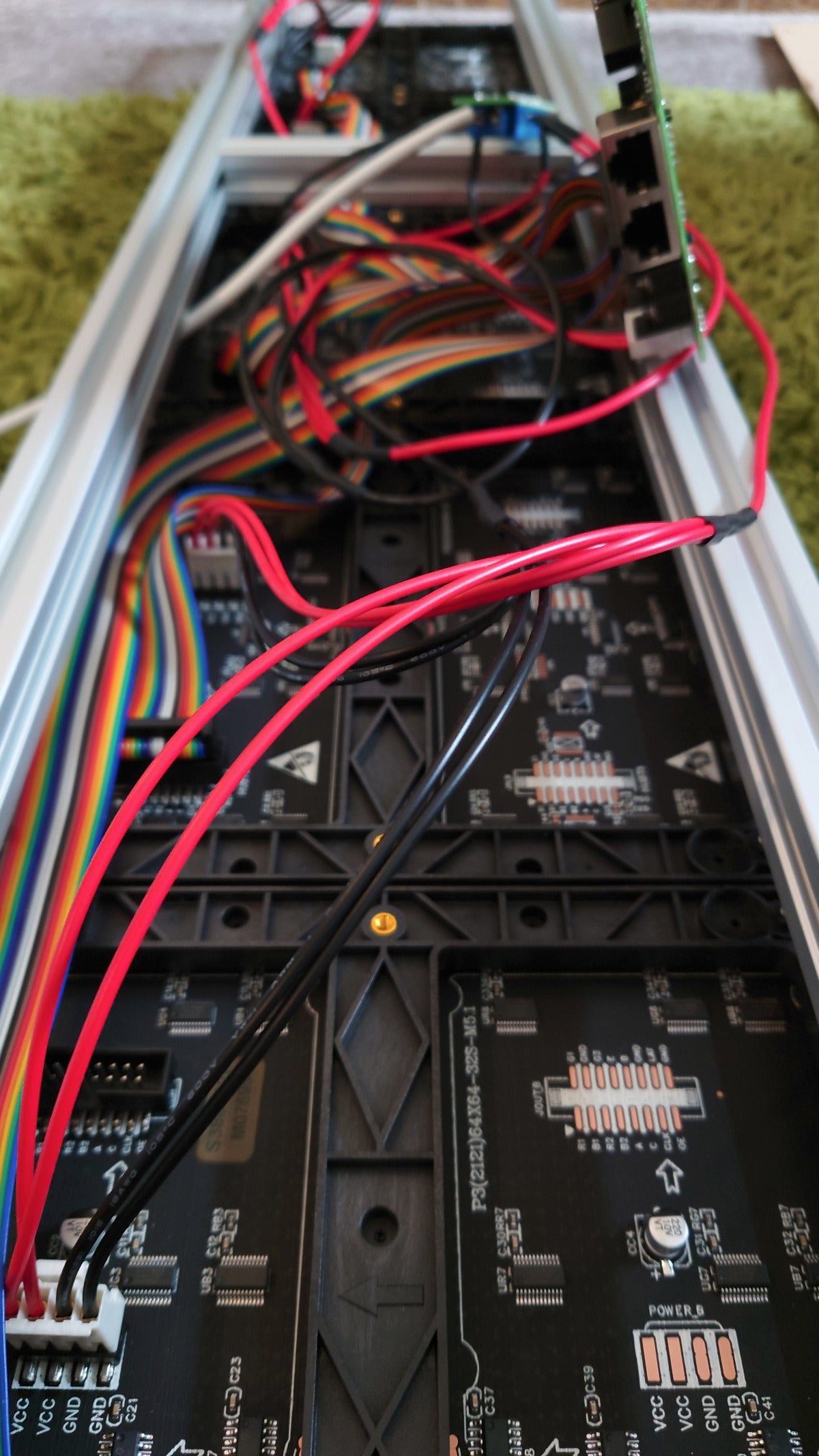 Close-up of electronic equipment with red and black wires on a green surface