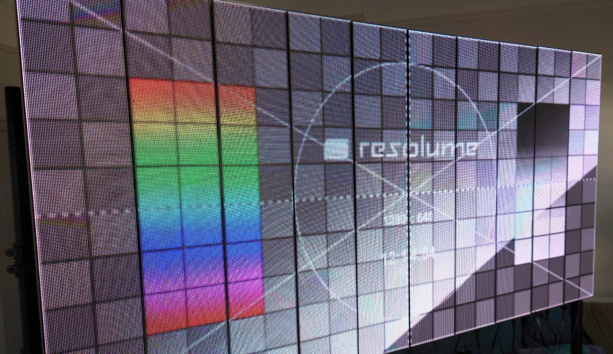 Large LED screen displaying a colorful test card pattern with 'Resolume' software logo.