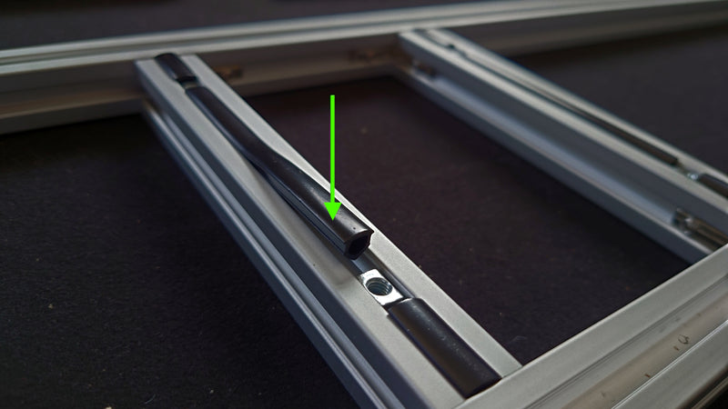Push the inserts into the cross bar tracks, with the larger insert in the centre, separating the T-nuts.