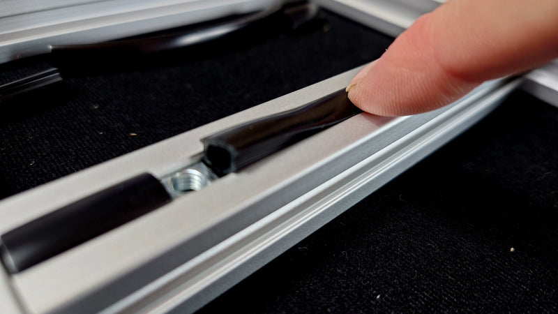 Push the inserts into the cross bar tracks, with the larger insert in the centre, separating the T-nuts.